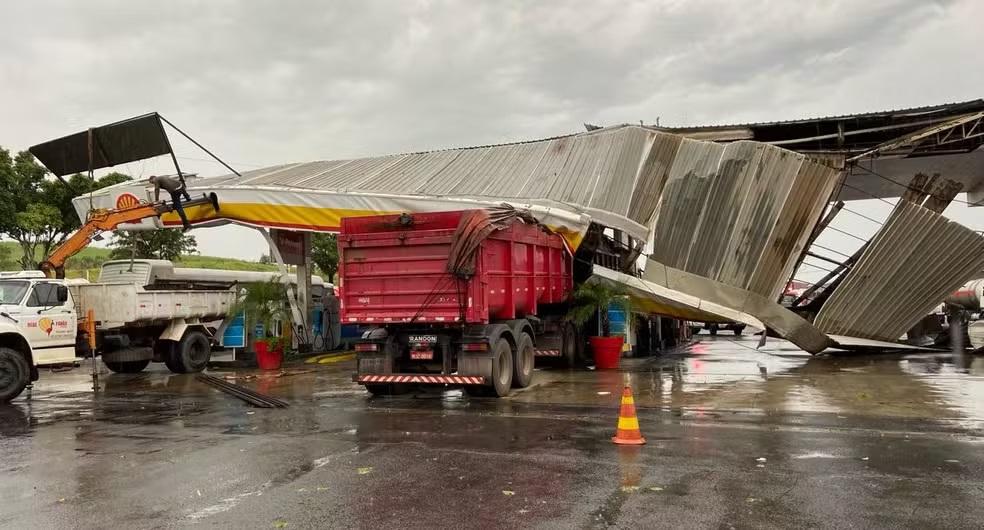 Chuva derruba cobertura de posto, árvores e causa alagamentos na região